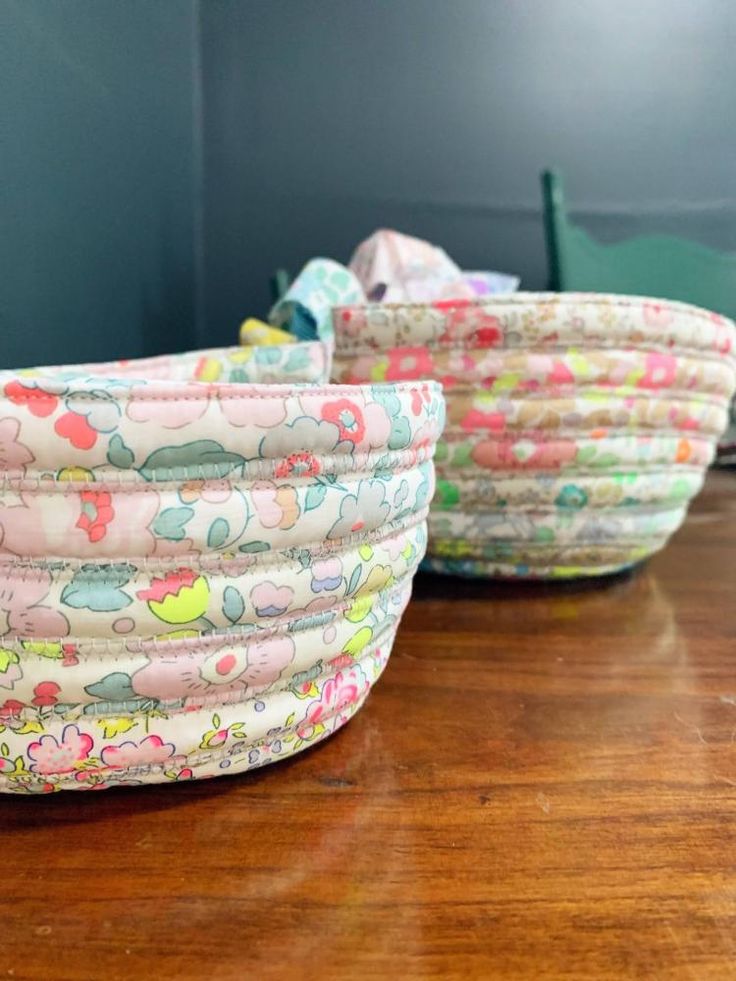 three baskets sitting on top of a wooden table next to each other with different designs