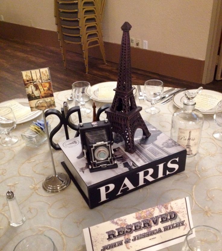 the table is set up with wine glasses and an eiffel tower model on it