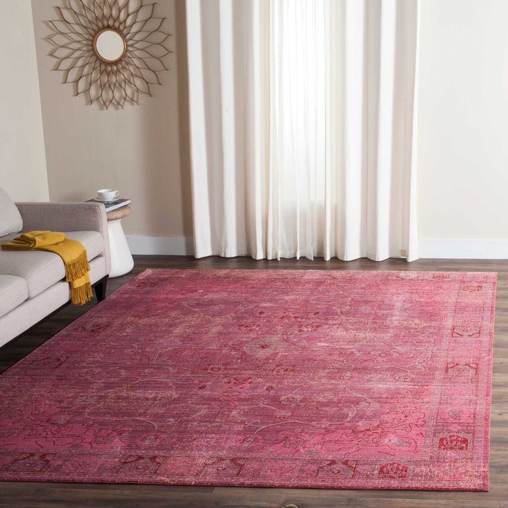 a living room area with a couch, chair and rug in front of a window