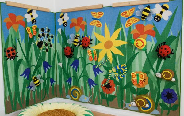 a child's room decorated with bugs and flowers on the wall, along with a dog bed