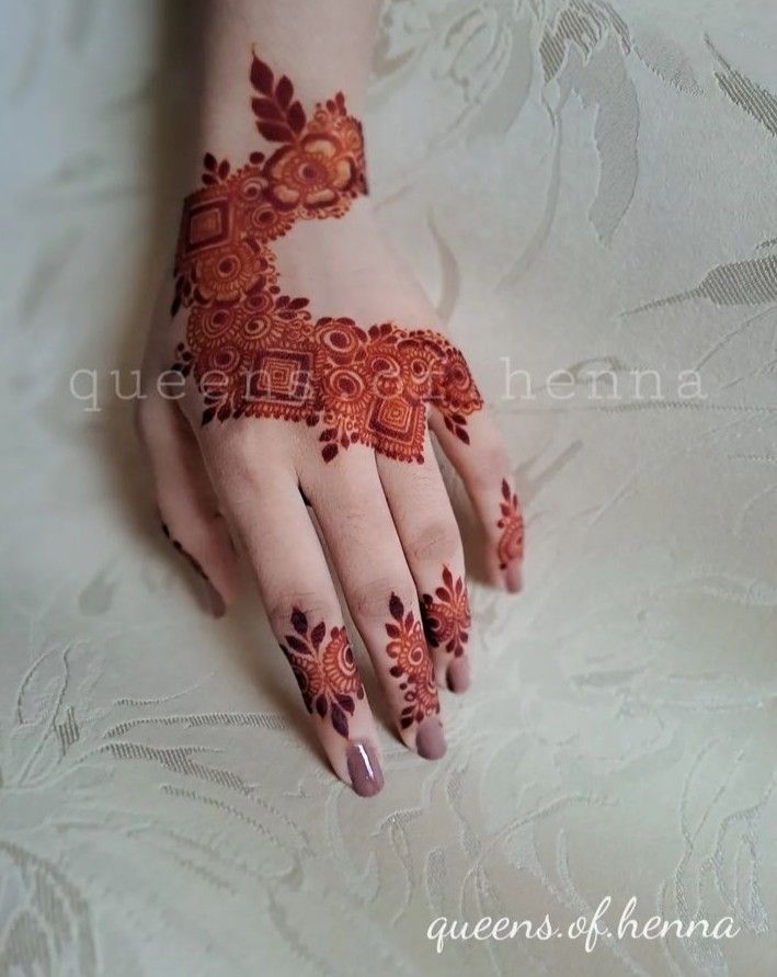 a woman's hand with henna tattoos on it