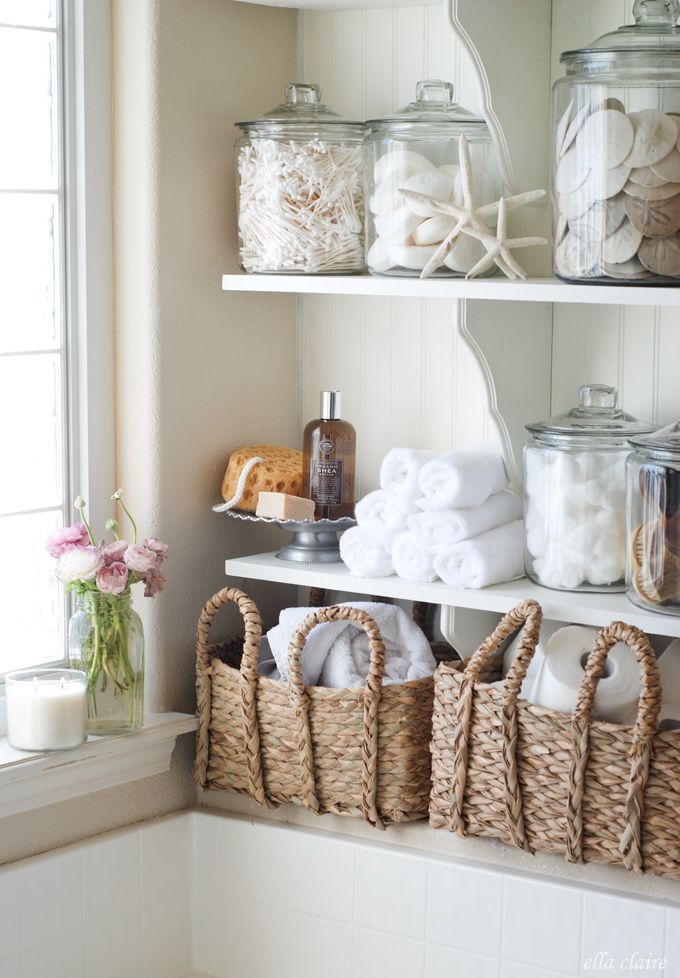 the bathroom shelves are filled with towels and other bath accessories, including baskets for toiletries