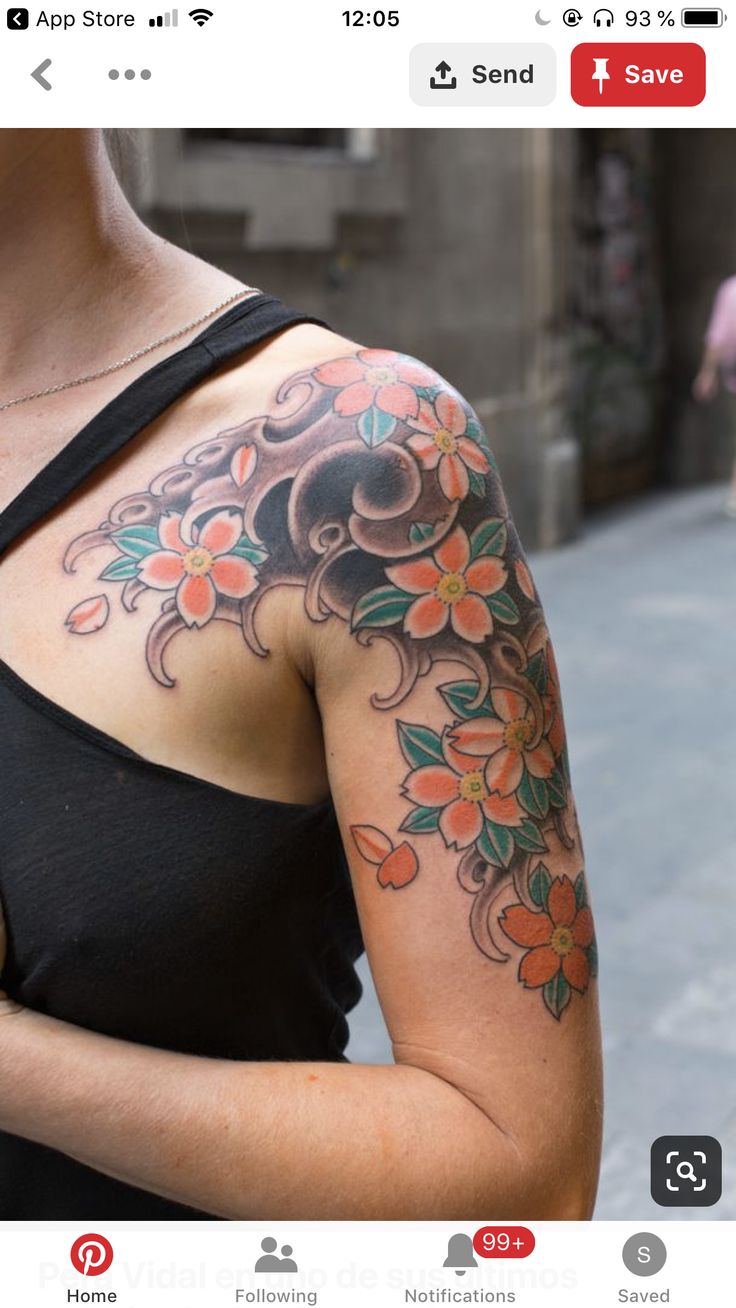 a woman with a flower tattoo on her arm holding a cell phone in her hand