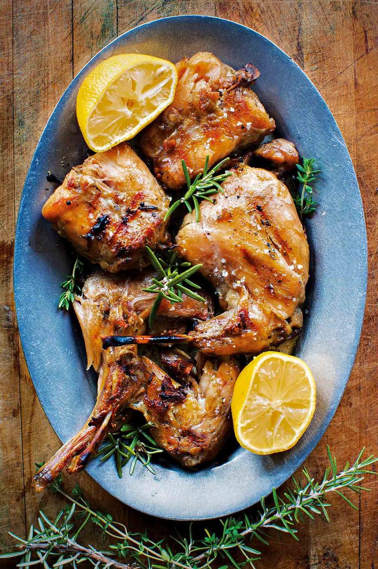 grilled chicken with lemons and rosemary on a blue plate