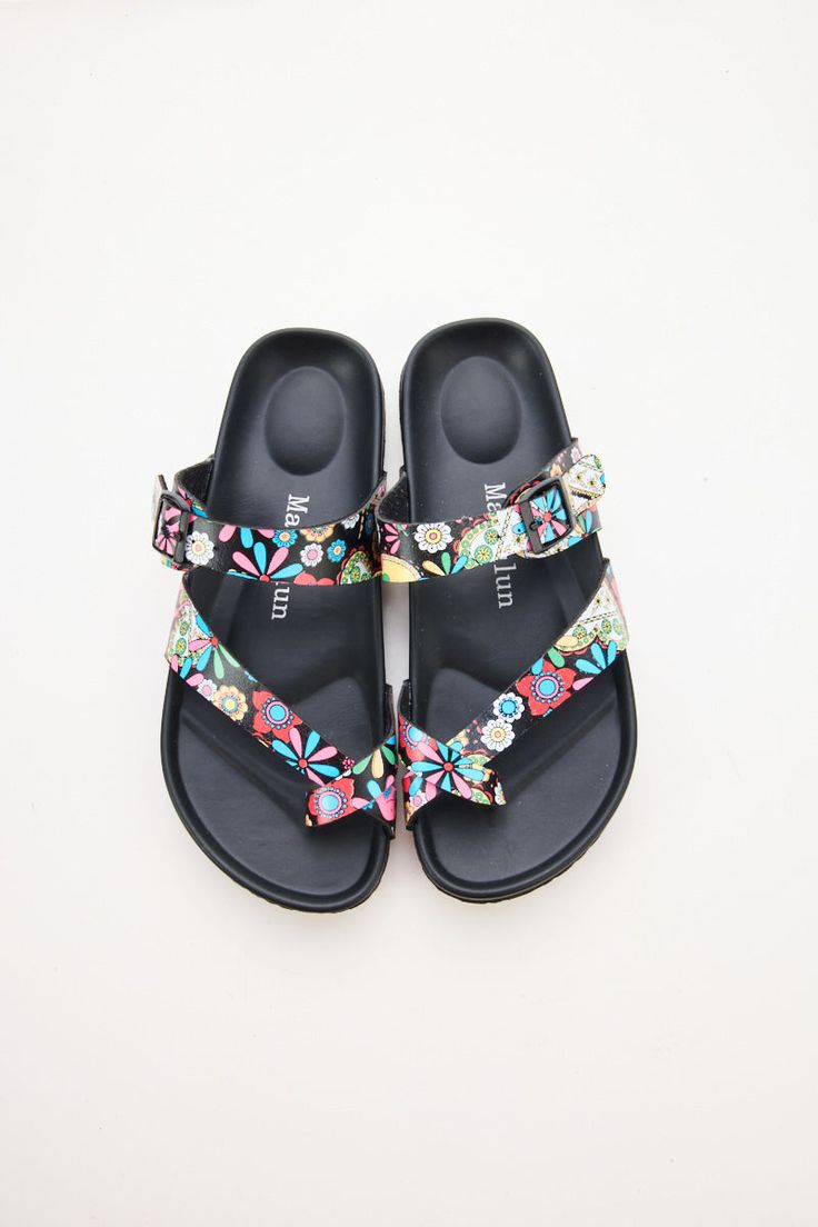 Step into comfort and style with Maibulun Thong Toe Cushioned Footbed Sandals. Designed with a cushioned footbed and thong toe, these sandals provide the perfect blend of support and style. The multi tropical prints adds a pop of color to any outfit, making these sandals a versatile addition to your wardrobe. 0.59" inch heel Slip-on / buckle closure Soft Cushioned footbed Man-made leather upper Man-made lining PU sole Comfortable Toe Post Footbed Sandals For Spring, Spring Comfortable Toe Post Footbed Sandals, Spring Flat Footbed Sandals With Arch Support, Adjustable Leather Footbed Slippers For Spring, Beach Footbed Sandals With Toe Post, Beach Footbed Sandals With Arch Support And Flat Heel, Adjustable Summer Footbed Sandals With Arch Support, Cushioned Single Toe Strap Flip Flops For Summer, Beach Footbed Sandals With Arch Support