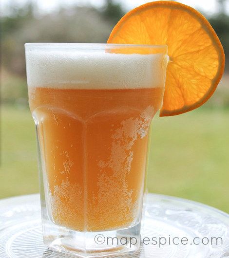 an orange slice is sitting next to a glass of beer on a table with the caption peach moon