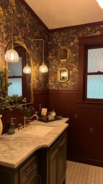 a bathroom with marble counter tops and wood paneling on the walls, along with stained glass windows