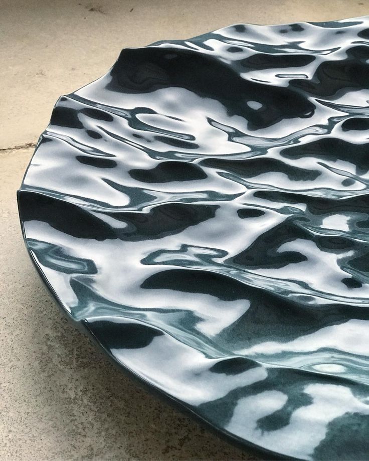 a black and white plate sitting on top of a cement floor