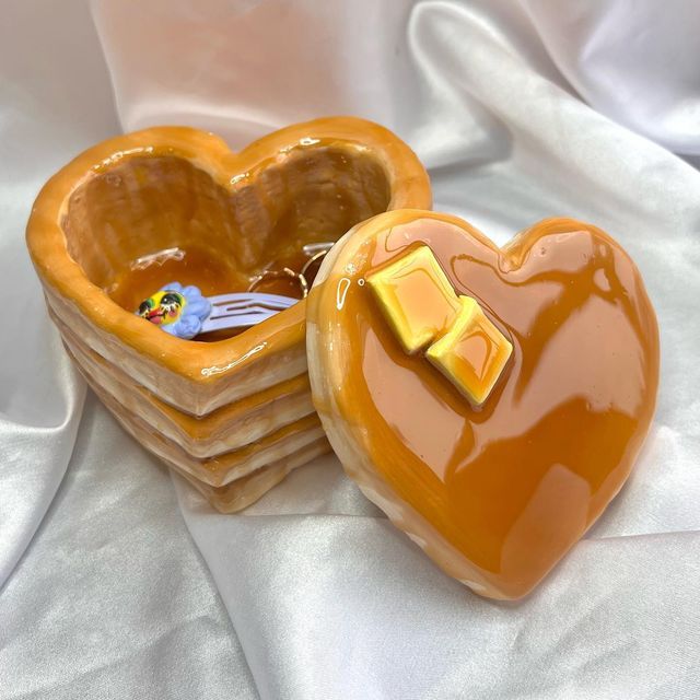 two heart shaped cookies sitting next to each other on top of a white table cloth