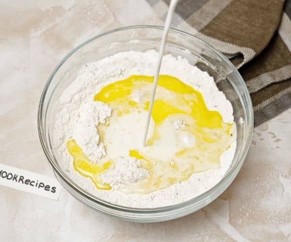 a glass bowl filled with flour and yellow liquid