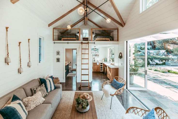 a living room filled with furniture next to a tall wooden ceiling mounted high in the air