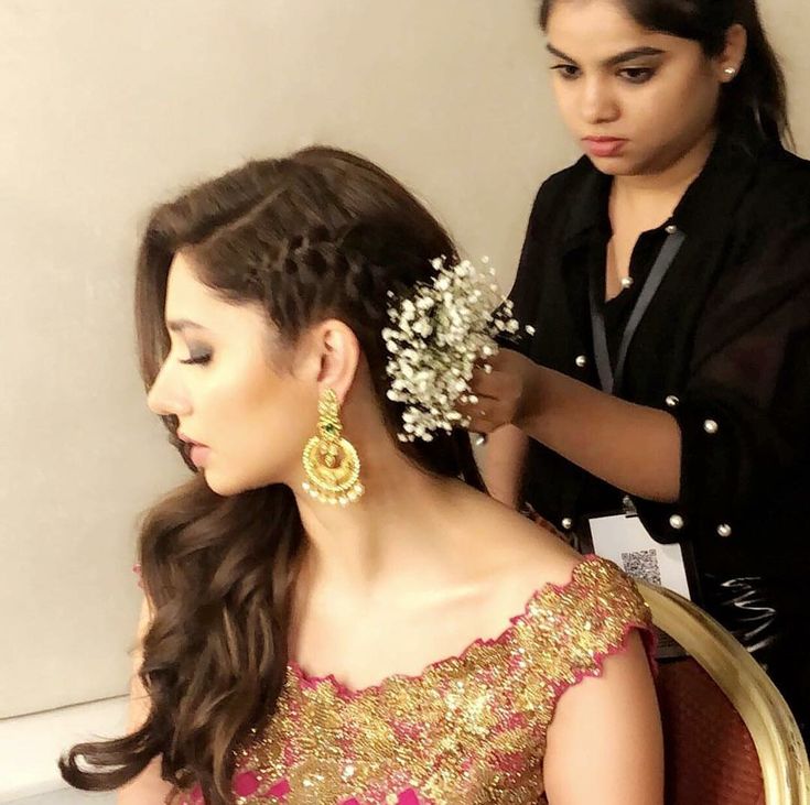 a woman is getting her hair done by another woman in a black shirt and gold dress