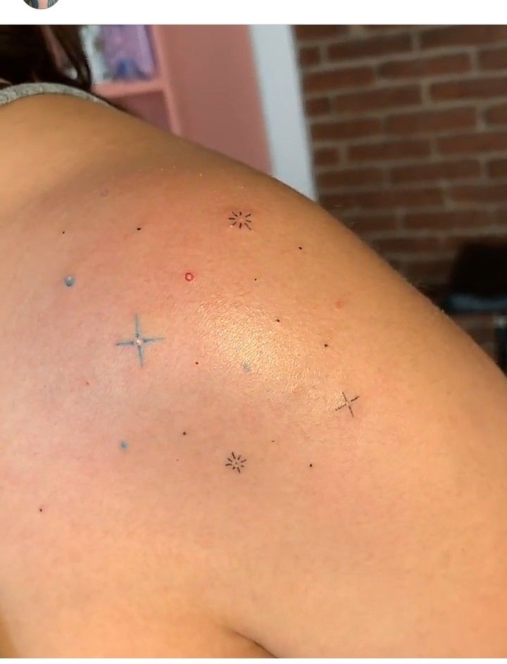 the back of a woman's shoulder with small stars on it