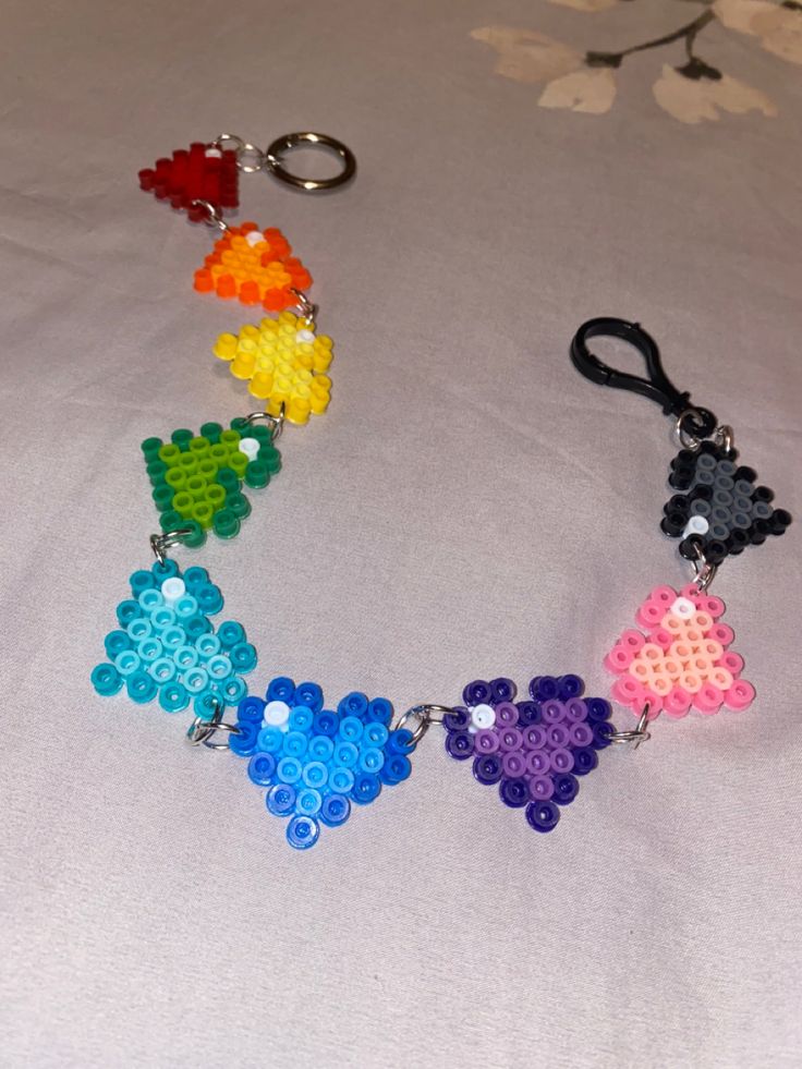 a multicolored beaded key chain on a white surface with flowers in the background