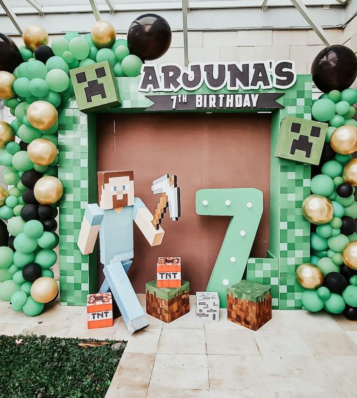 a minecraft themed birthday party with balloons, decorations and paper machi figures in front of the number seven