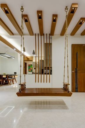 a living room filled with lots of furniture and wooden beams hanging from the ceiling above