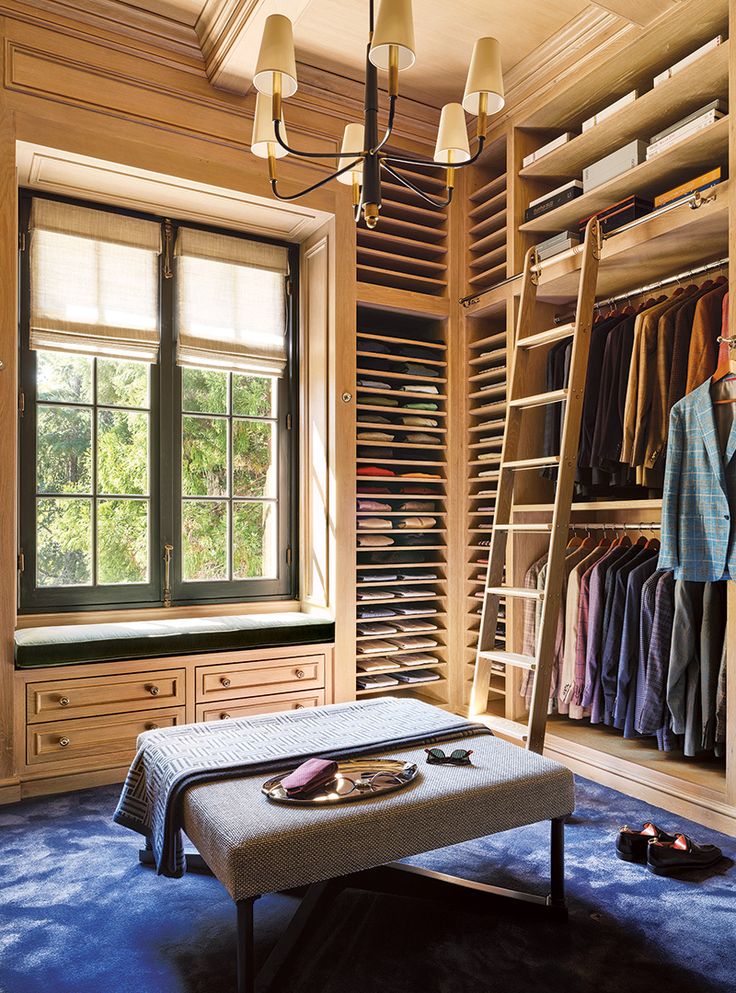 a room with a ladder and clothes on the shelves