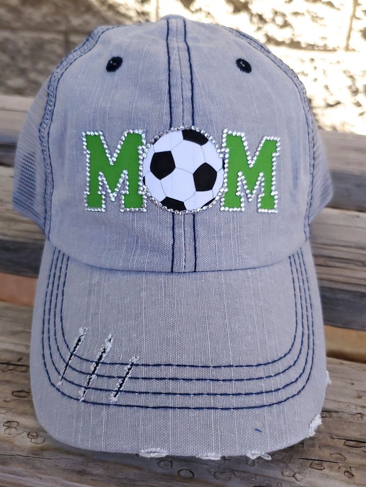 Mom Bling Trucker Cap, Soccer Mom Women's Trucker Hat, Distressed Soccer Hat, Bling Soccer Hat Many hat colors to choose from, you choose team colors and personalization for hat. This design can be done for any sport! Listing pictures are of a slightly distressed grey denim washed trucker cap with light grey stitching and light grey mesh back and adjustable strap with pony tail opening. MOM is on front in green with a rhinestone soccer ball YOU CAN ADD ADDITIONAL NAME or NUMBER PERSONALIZATION- Adjustable Fun Hats For Sports Events, Adjustable Gray Hat For Sports Events, Green Sports Event Hat, One Size Fits Most, Gray Hat One Size For Sports Events, Green Sports Hat, One Size Fits Most, Gray Distressed Hat, One Size Fits Most, Adjustable Gray Distressed Hat, Embroidered Summer Baseball Cap With Visor, Adjustable Distressed Gray Baseball Cap