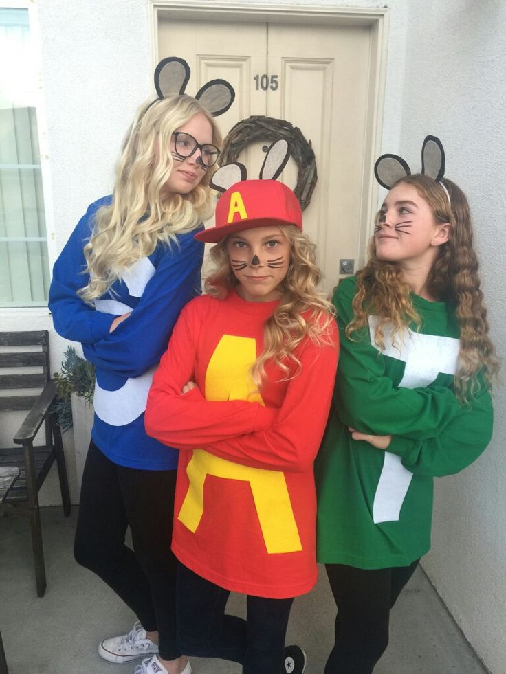 three women dressed up as mickey mouse and minnie mouse, standing in front of a door