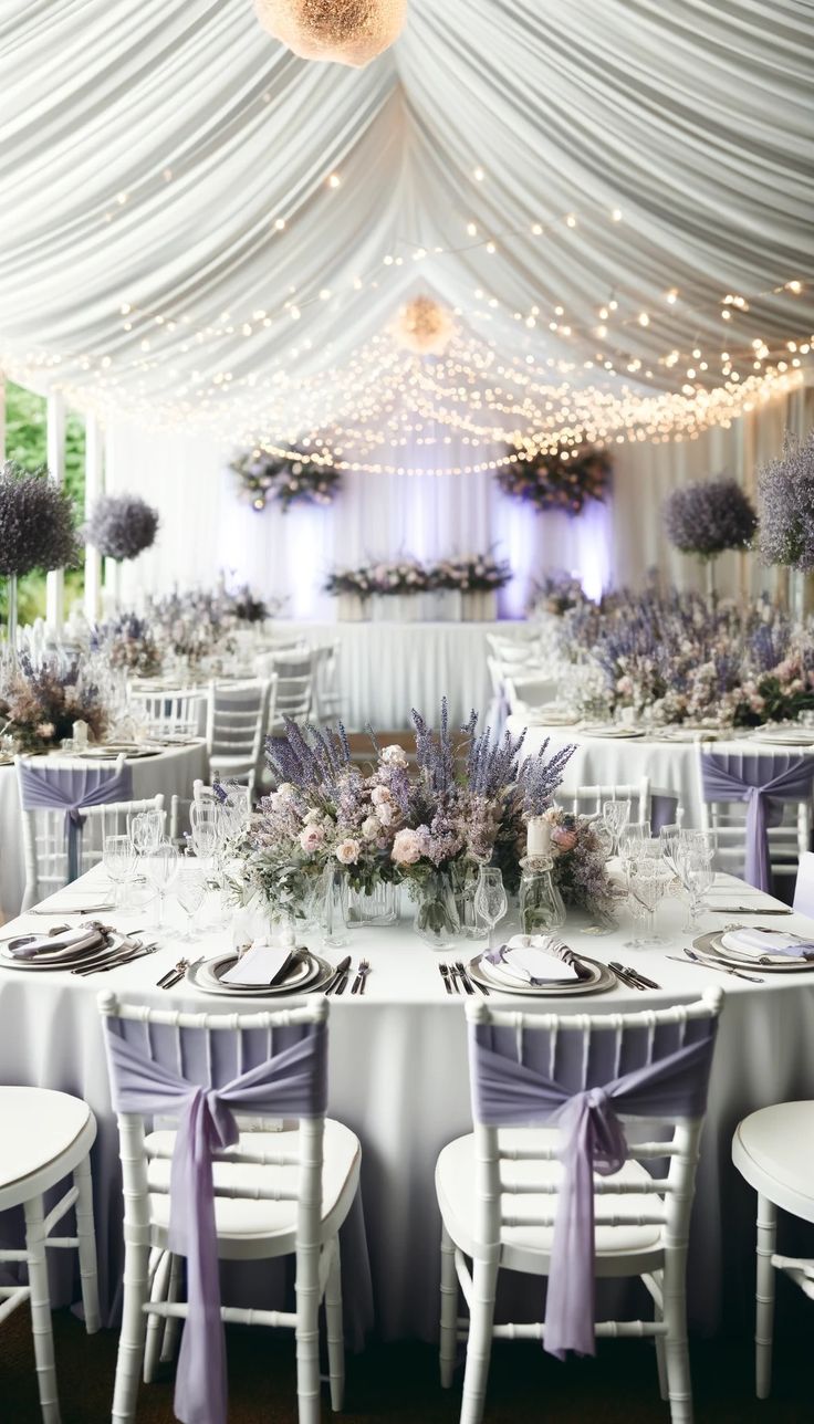 the tables are set with purple flowers and place settings for an elegant dinner or reception