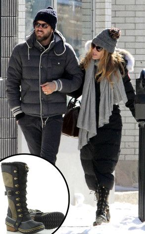 a man and woman walking down the street in the snow with one holding his hand