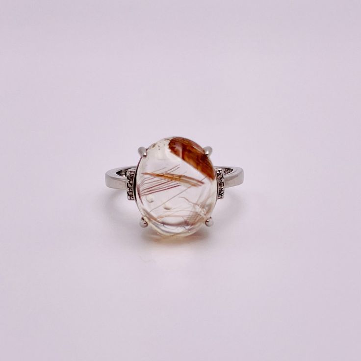 On A Peaceful Sunday At The Park, You Bask In The Gentle Warmth Of The Sun, Surrounded By Nature's Tranquility. As You Pause And Raise Your Hand To Pull Closer To You A Beautiful Rose To Smell, The Golden Threads Of Your Rutilated Quartz Ring Capture The Essence Of Sunlight, Infusing Your Touch With Mystical Allure. Details: 925 Sterling Silver Ring Polished Oval Clear Quartz With Golden Rutiles Stone 0.5in Stone Length Adjustable Size Cheese Ring, Rutilated Quartz Jewelry, Peaceful Sunday, Rough Quartz, Custom Diamond Rings, Your Touch, Rutilated Quartz Ring, Rose City, Swarovski Ring