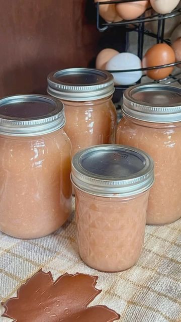 four jars filled with peanut butter sit on a table next to an egg and some other items