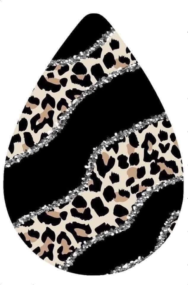 an animal print tear shaped with silver glitter on black and white stripes in the shape of a cheetah