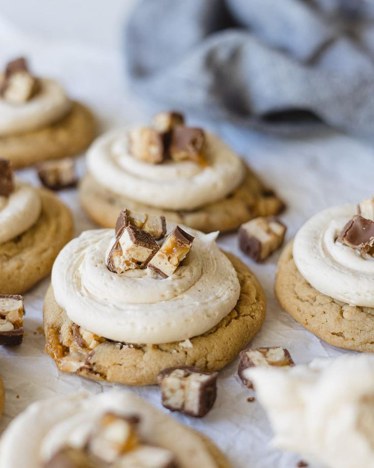 several cookies with white frosting and chopped walnuts on top are sitting on a table