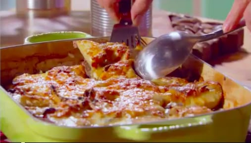 a person is scooping some food out of a casserole dish with a spatula