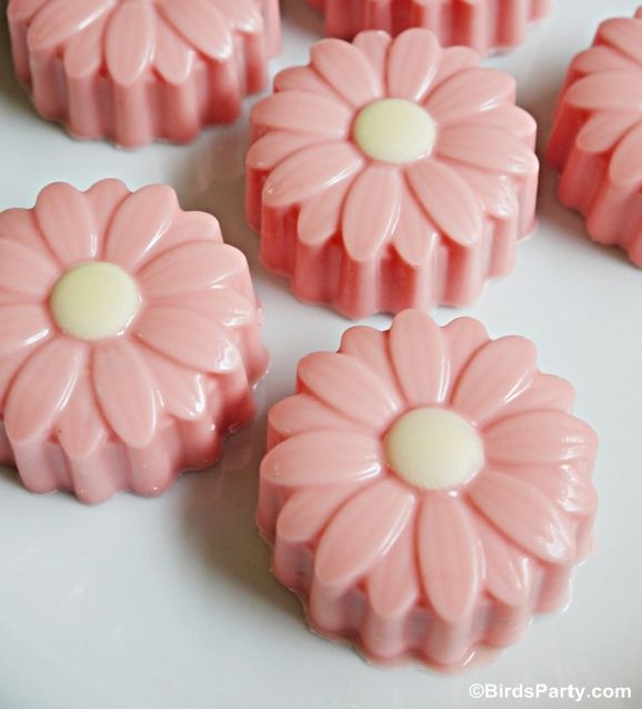 small pink flowers are sitting on a white plate and ready to be used as candies