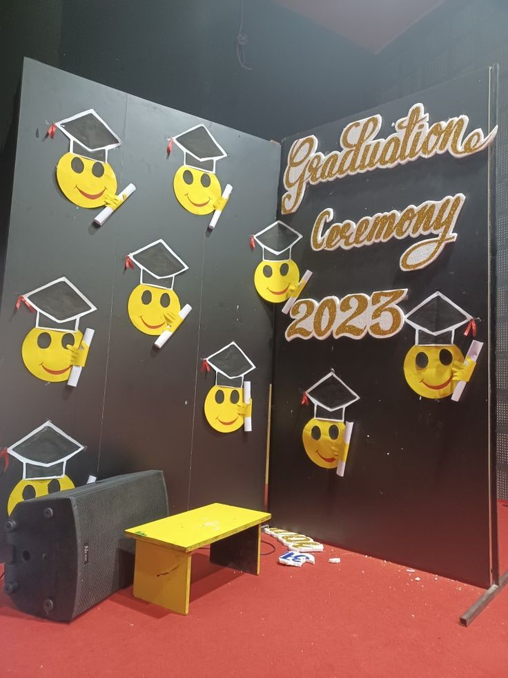 graduation decorations are on display in front of a wall with smiley faces and graduation caps