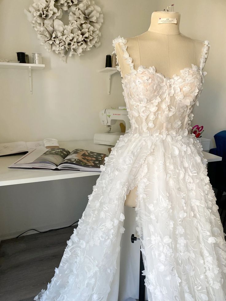 a white dress on display in front of a mannequin's head and neck