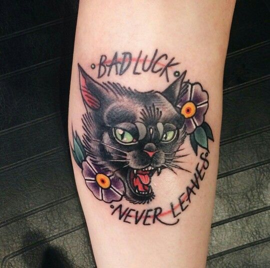 a black cat with flowers on it's leg that says bad luck never leaves