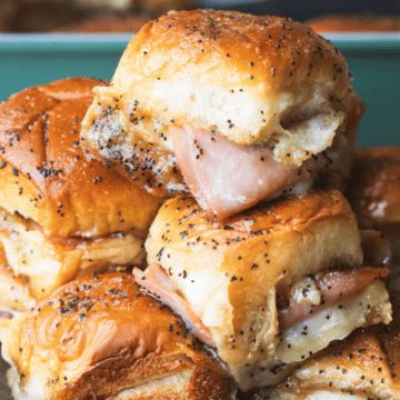 a pile of pigs in a blanket sitting on top of a blue dish filled with bread