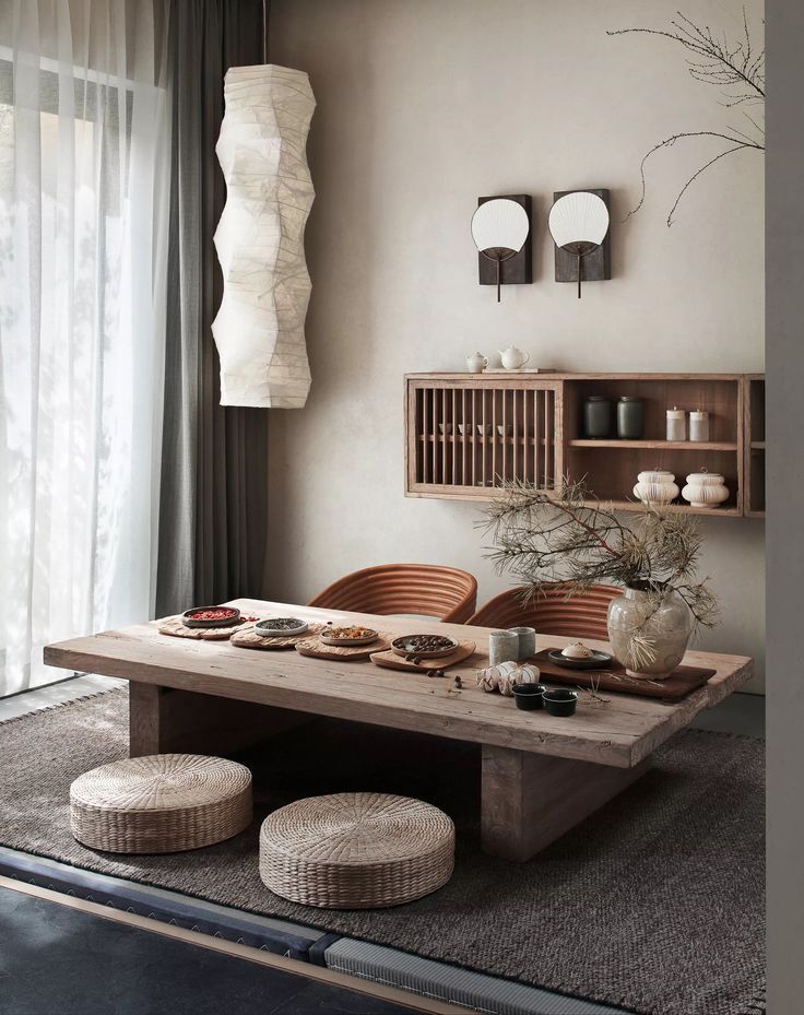 a dining room table with two stools in front of it and an open shelf on the wall