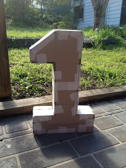 the number one is made out of cardboard and placed in front of a brick walkway