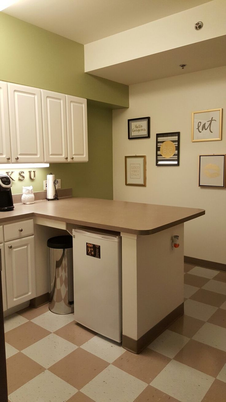 a kitchen with white cabinets and checkered flooring on the floor is seen in this image