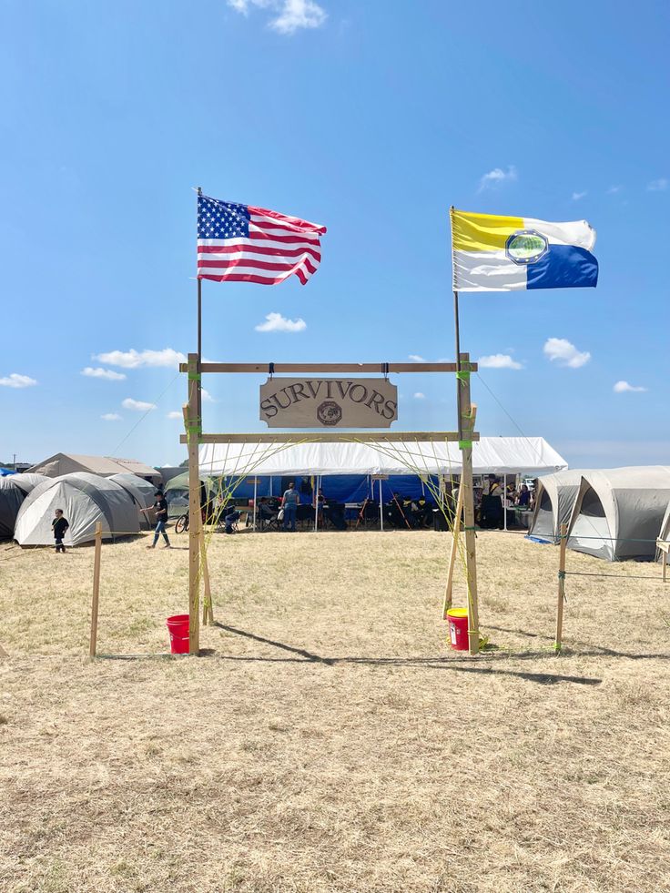 two flags are flying in the air near a sign