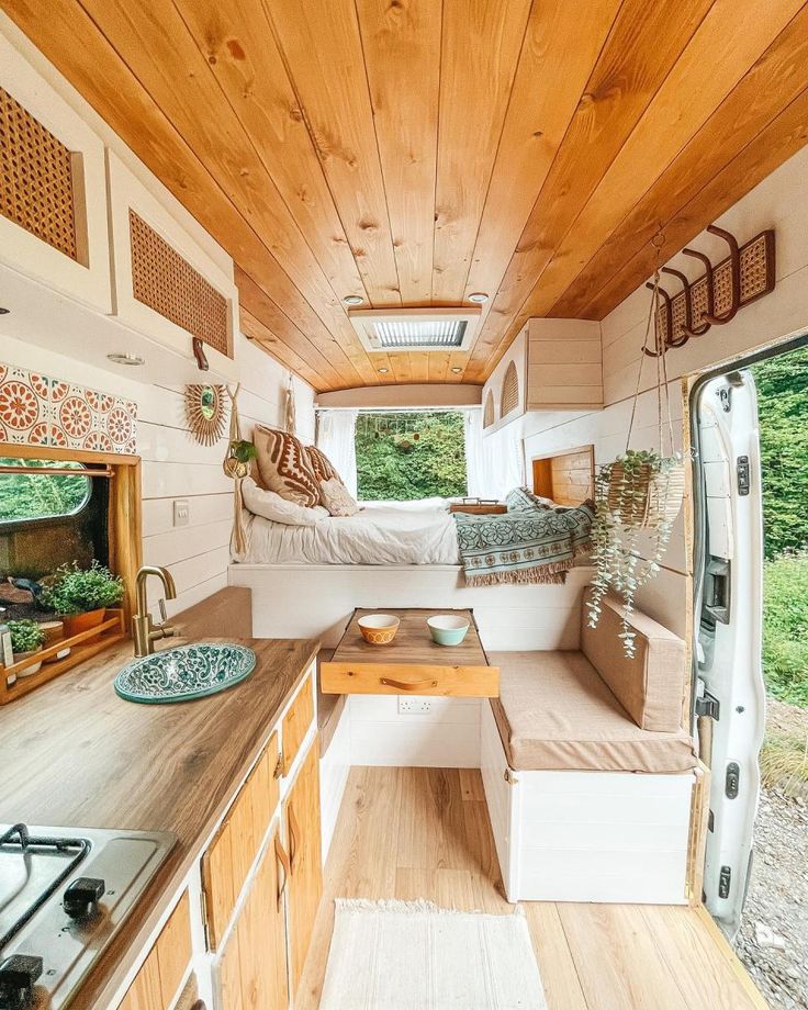 an interior view of a tiny home with wood paneling and white furniture, including a bed