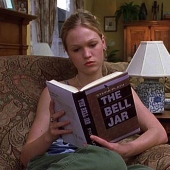 a woman sitting on a couch reading a book