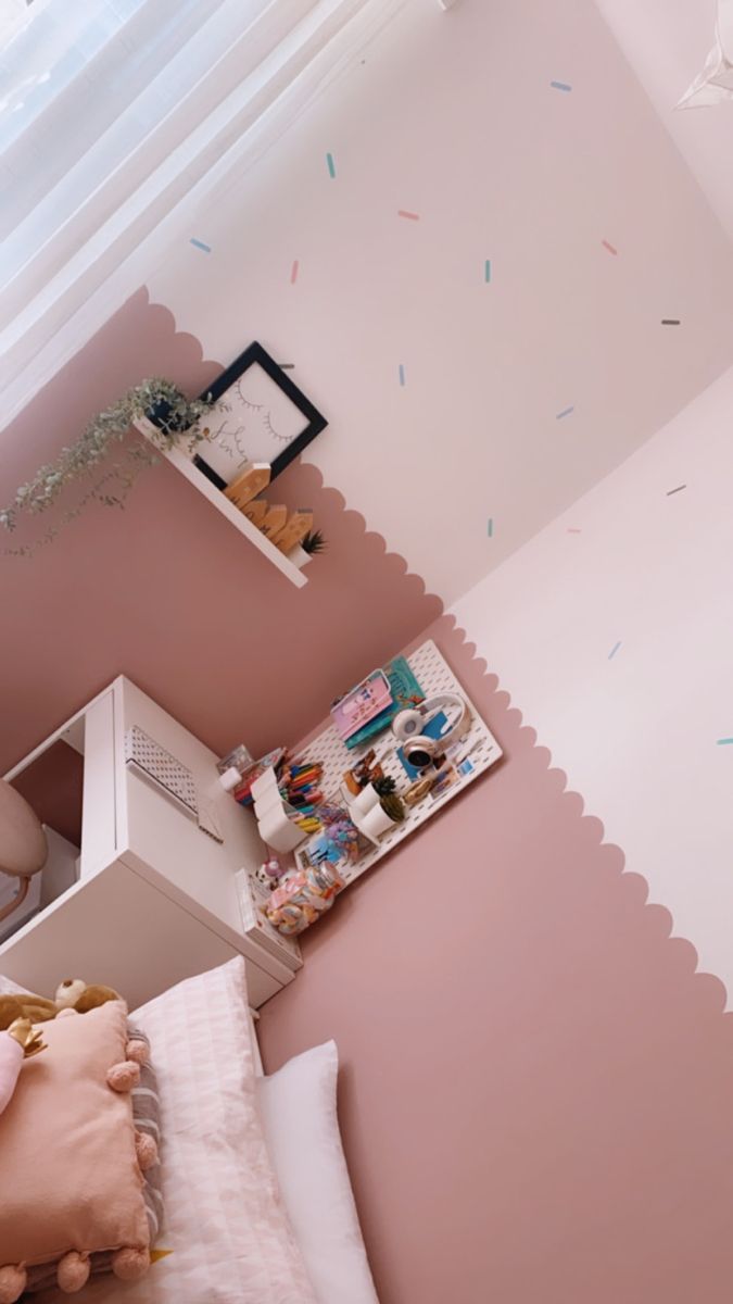 a small bedroom with pink walls and white trim on the ceiling is decorated with confetti sprinkles