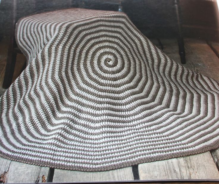 a black and white rug sitting on top of a wooden floor next to a chair