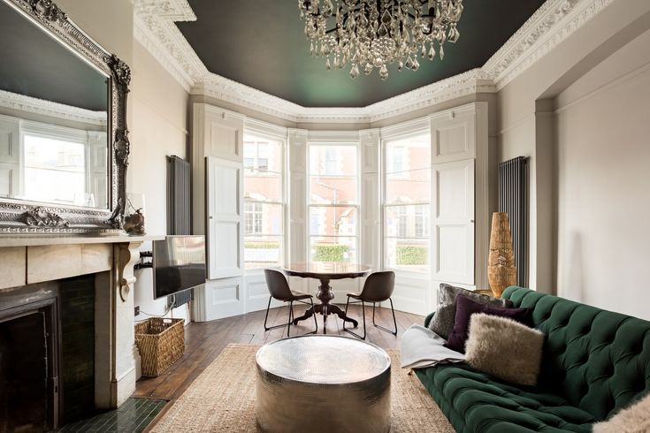 a living room filled with furniture and a fire place under a chandelier hanging from the ceiling