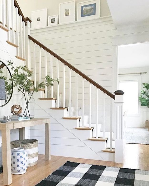 a living room filled with furniture and a stair case next to a wooden table on top of a hard wood floor