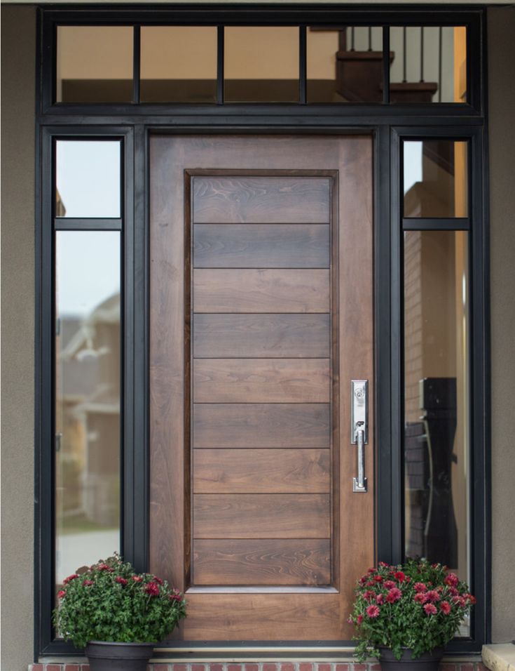 a wooden door with two planters on the side