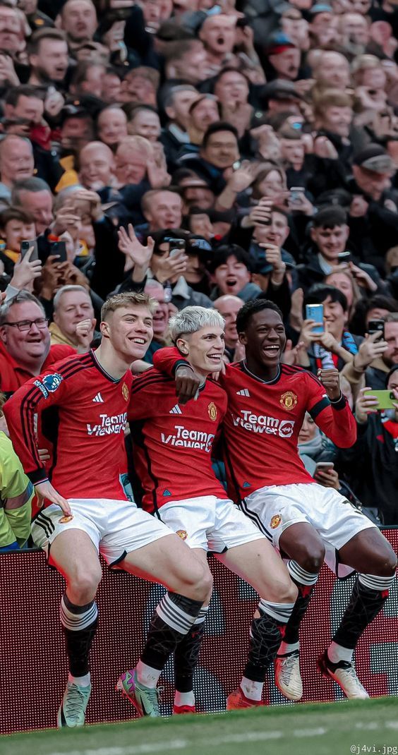 the soccer players are celebrating their goal in front of an audience at a sporting event