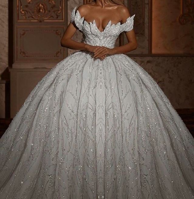 a woman in a white ball gown with silver sequins