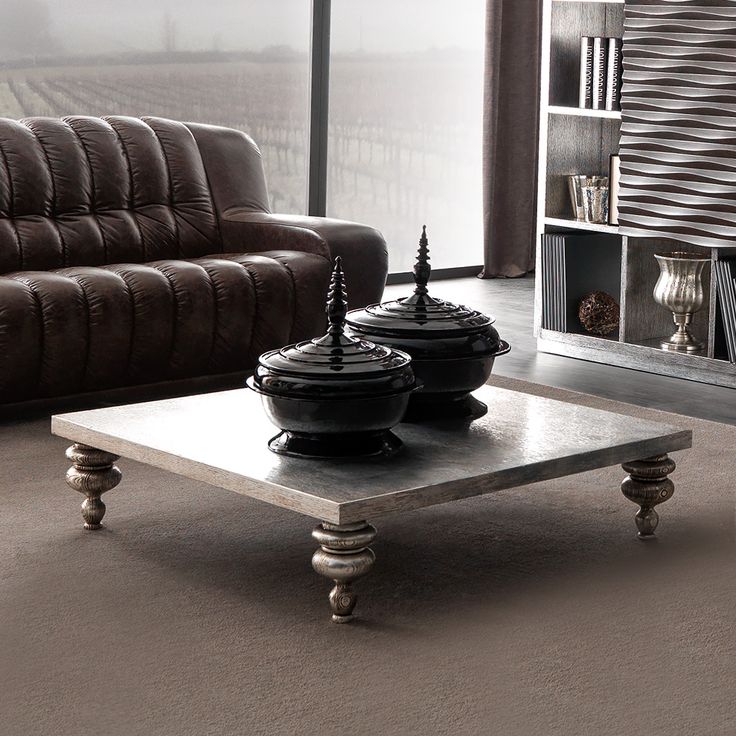 two black pots sitting on top of a coffee table in front of a brown couch