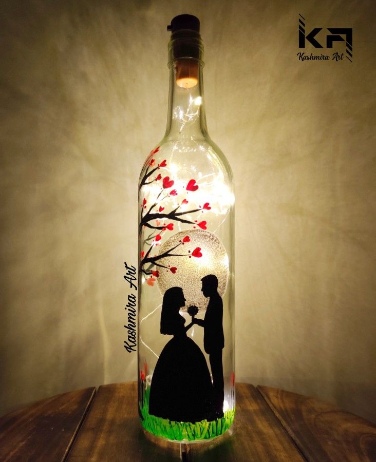 a lighted bottle with a silhouette of a man and woman holding an umbrella on it